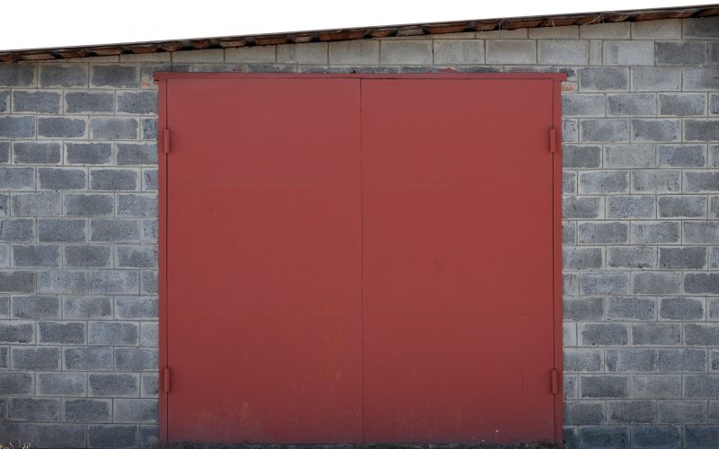 The texture of a painted metal gate from a brick garage The texture of a painted metal gate from a brick garage