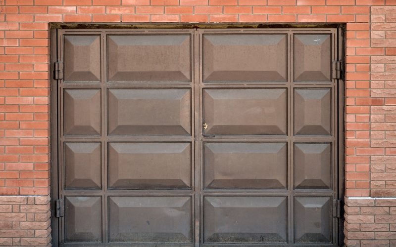 The texture of a painted metal gate from a brick garage The texture of a painted metal gate from a brick garage